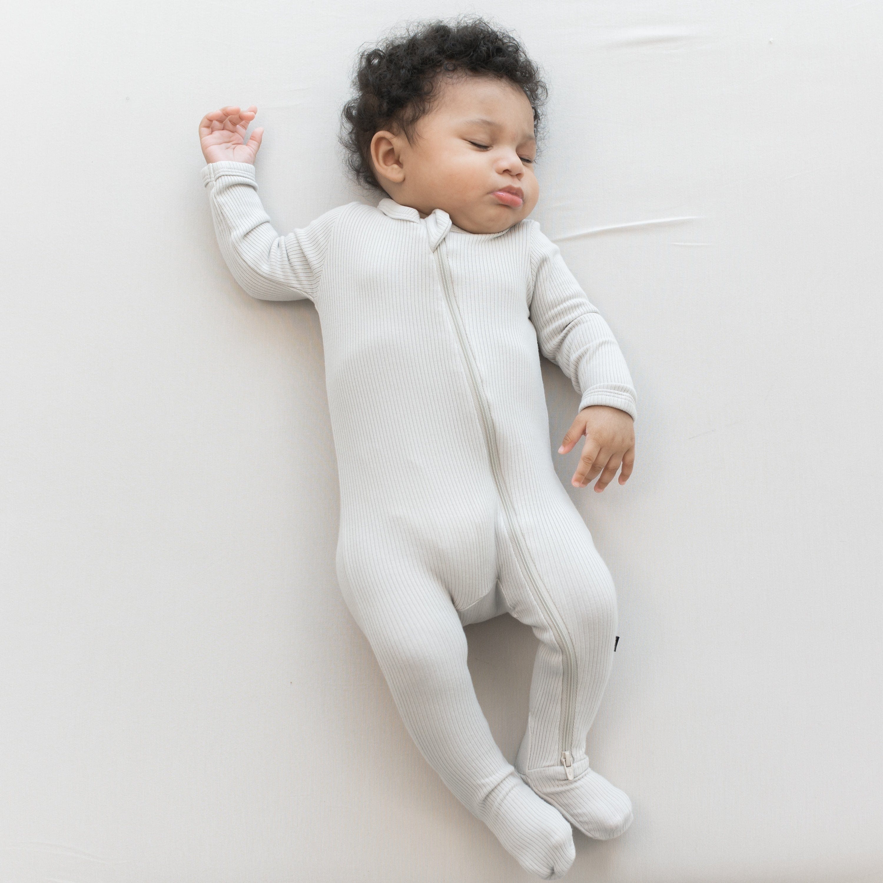 Kyte Baby ribbed zipper footie pajamas in oat warm neutral off-white