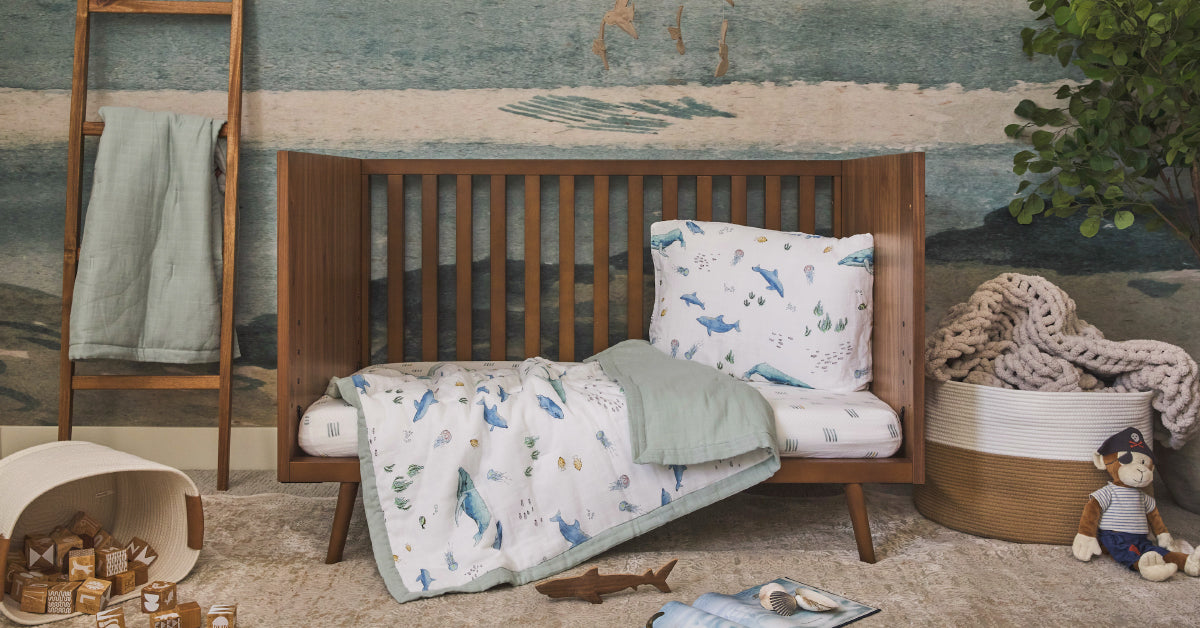 Little Unicorn cotton muslin outdoor blanket spread on grass — gift for outdoorsy parents with baby